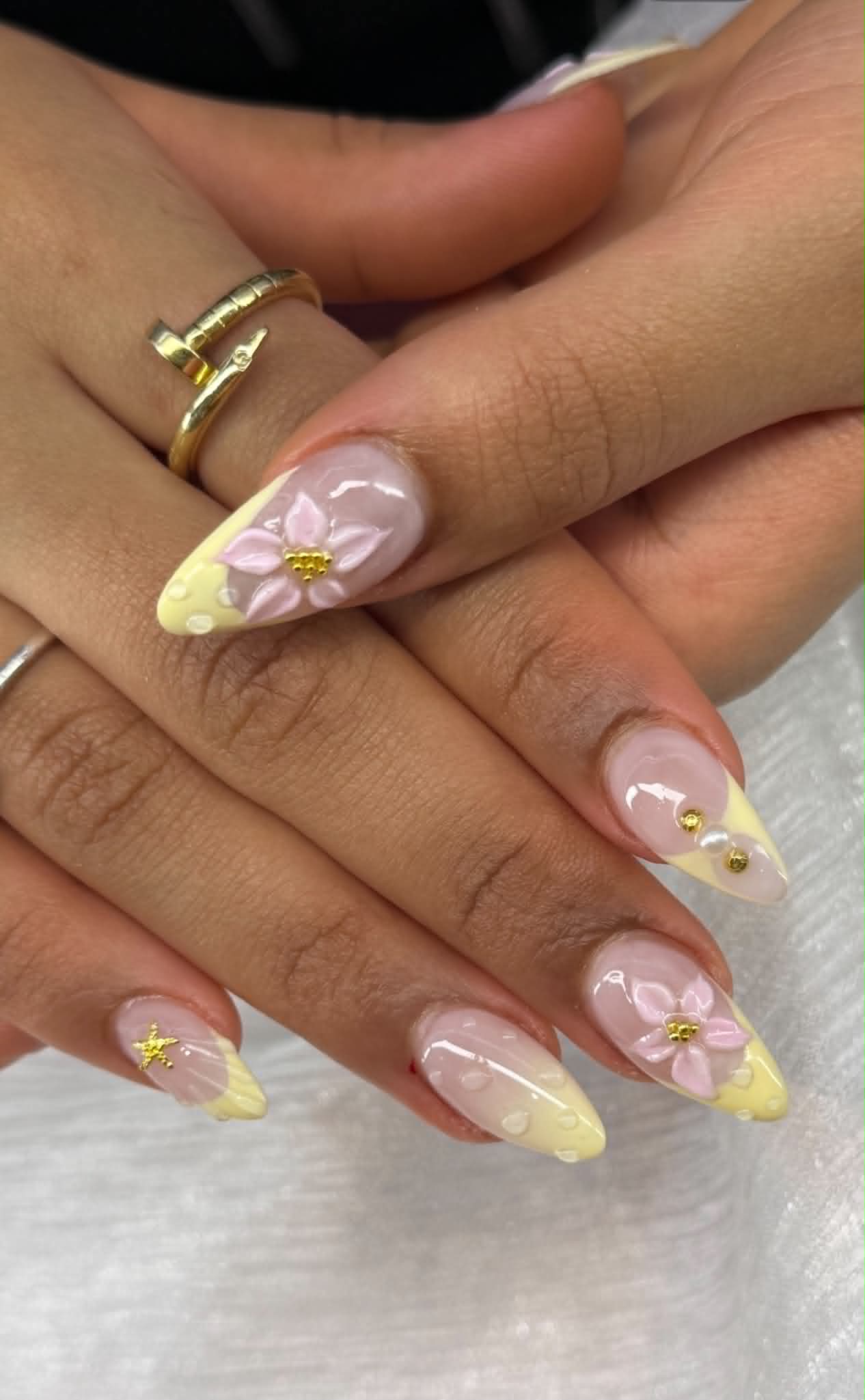 Pastel yellow French tips with 3D pink flowers and gold accents